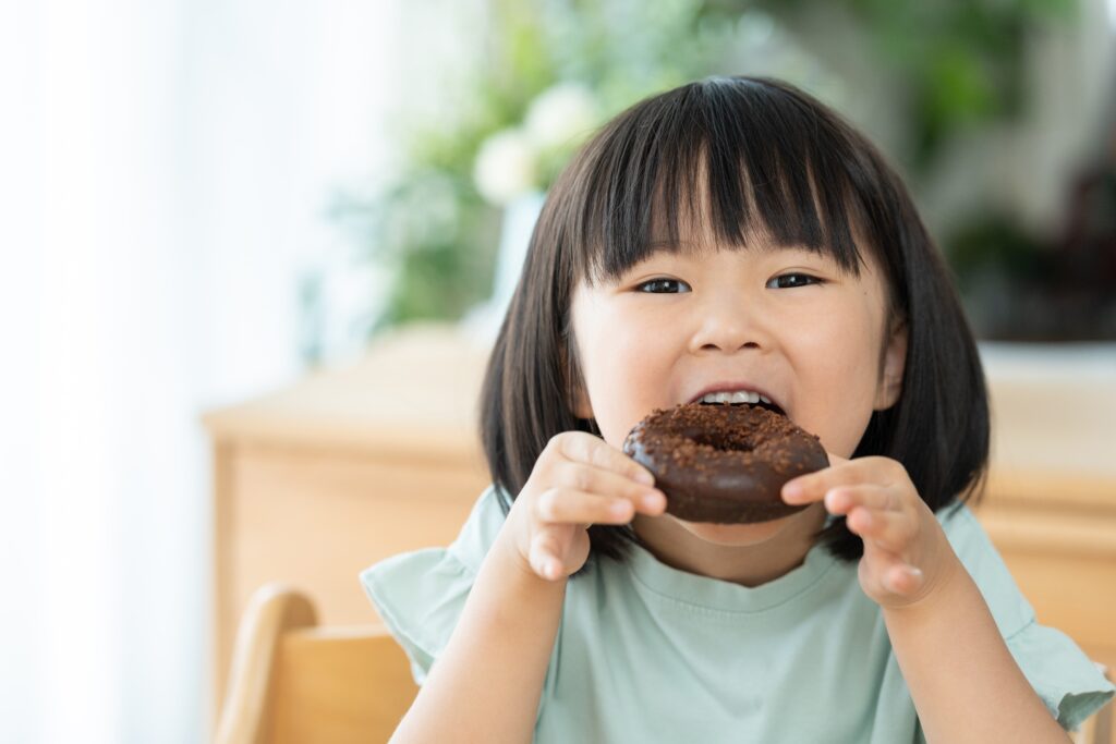 ドーナツを食べている子供