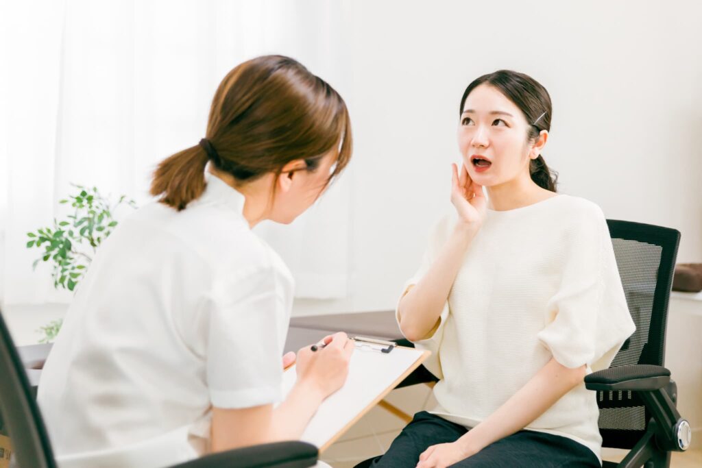 嚙み合わせが悪いまま放っておくとどうなるか医師に相談する女性患者